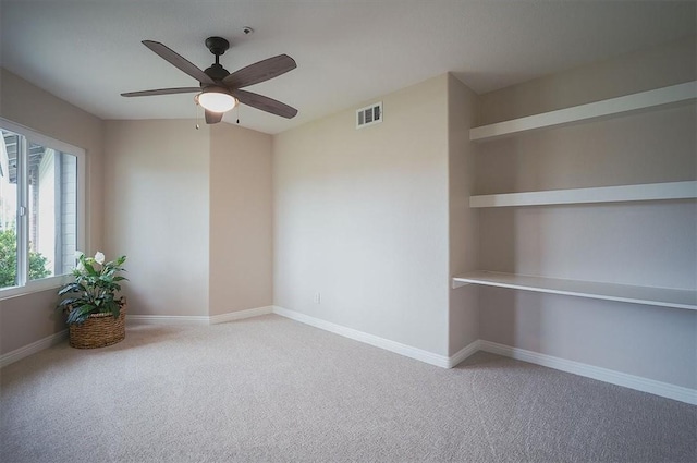 spare room with a ceiling fan, carpet, and baseboards