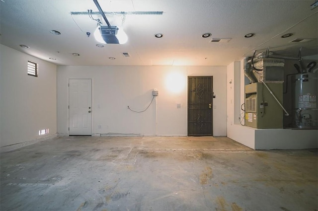 garage featuring water heater, recessed lighting, a garage door opener, and heating unit