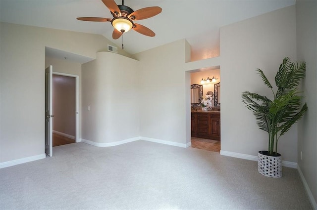 unfurnished room with a ceiling fan, lofted ceiling, light colored carpet, and baseboards