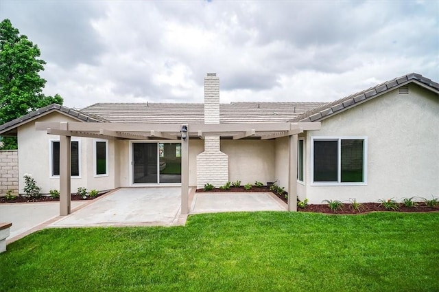 rear view of house with a pergola, a chimney, stucco siding, a patio, and a lawn