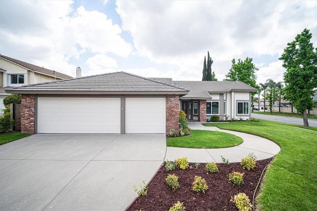 view of front of property featuring a garage, concrete driveway, a front yard, and brick siding
