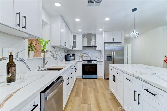 10612 Ketch Ave, Garden Grove, CA 92843 - kitchen with appliances with stainless steel finishes, wall chimney exhaust hood, white cabinets, recessed lighting, and light wood finished floors
