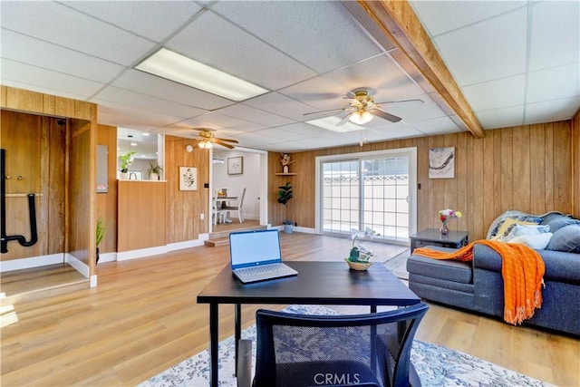 10612 Ketch Ave, Garden Grove, CA 92843 - living room featuring a ceiling fan, wooden walls, wood finished floors, and a paneled ceiling