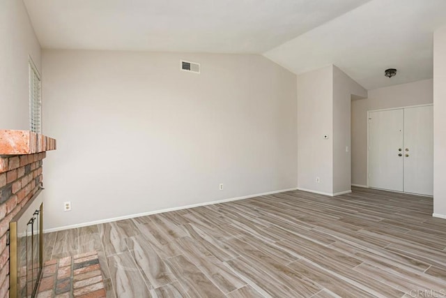 4616 Arrowhead Ct, Oceanside, CA 92056 - unfurnished living room featuring light wood finished floors, vaulted ceiling, a brick fireplace, and baseboards