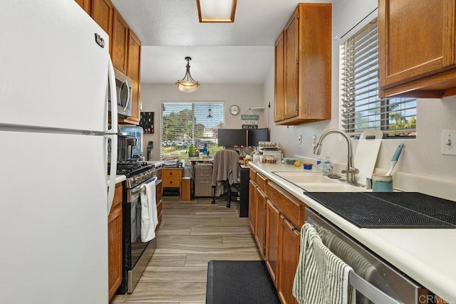 4616 Arrowhead Ct, Oceanside, CA 92056 - kitchen featuring appliances with stainless steel finishes, a sink, brown cabinets, light countertops, and a desk