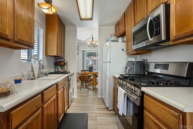 4616 Arrowhead Ct, Oceanside, CA 92056 - kitchen with appliances with stainless steel finishes, a sink, brown cabinets, a chandelier, and light countertops