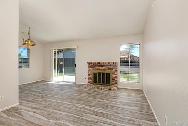 4616 Arrowhead Ct, Oceanside, CA 92056 - unfurnished living room with plenty of natural light, baseboards, a brick fireplace, vaulted ceiling, and a chandelier