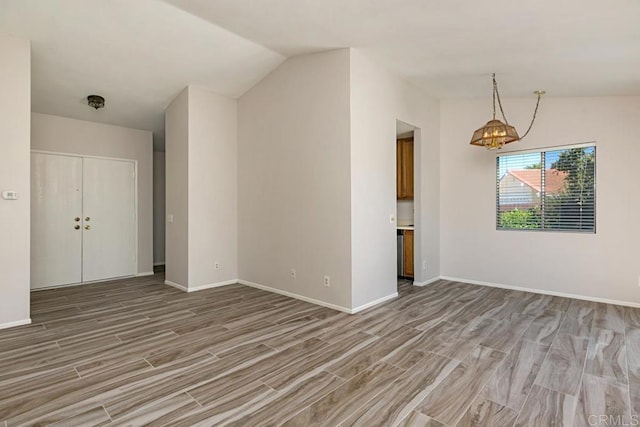 4616 Arrowhead Ct, Oceanside, CA 92056 - unfurnished living room with light wood-style floors, vaulted ceiling, a chandelier, and baseboards
