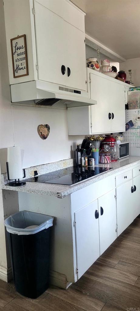 668 Farview St, El Cajon, CA 92021 - kitchen with white cabinets, black appliances, light countertops, and decorative backsplash