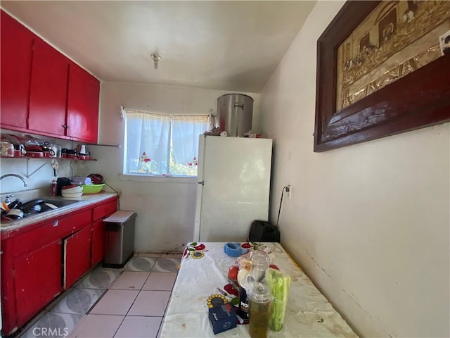 260 W 42nd Pl, Los Angeles, CA 90037 - kitchen featuring red cabinets, freestanding refrigerator, a sink, and light countertops