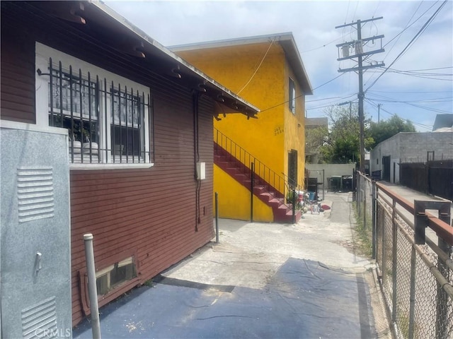 260 W 42nd Pl, Los Angeles, CA 90037 - view of side of home with fence, stairs, and a patio