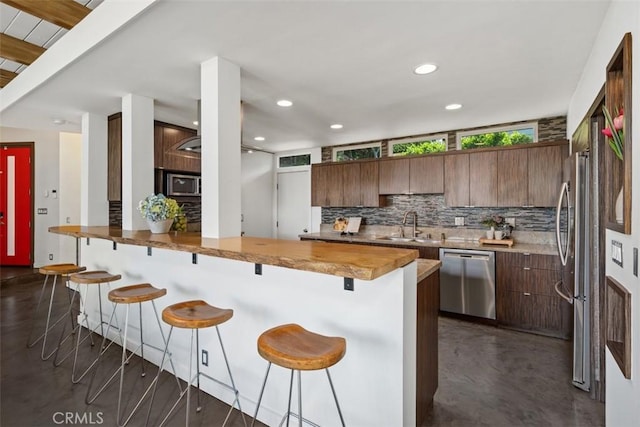 11575 Sunshine Ter, Studio City, CA 91604 - kitchen with stainless steel appliances, backsplash, a sink, a breakfast bar, and recessed lighting
