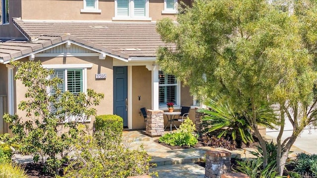 entrance to property with stucco siding and a tile roof