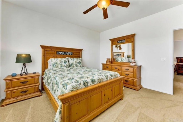 bedroom with light colored carpet, a ceiling fan, and baseboards