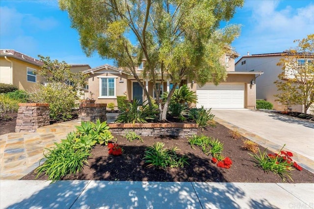 view of front of property with stucco siding, concrete driveway, and a garage