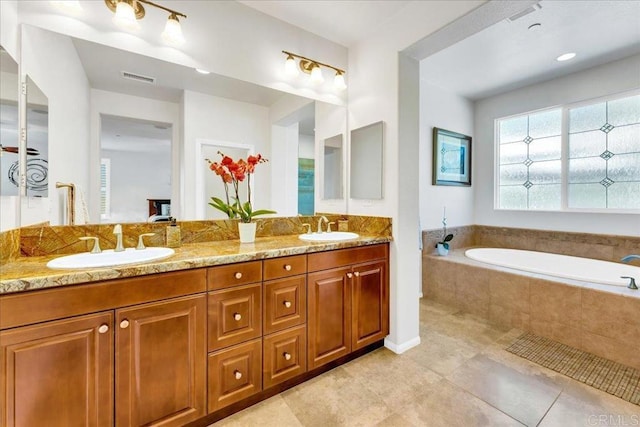 bathroom featuring a garden tub, double vanity, and tile patterned floors