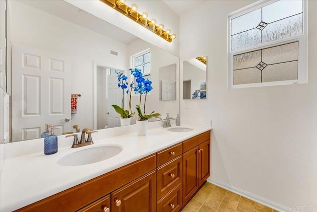 bathroom featuring baseboards and double vanity