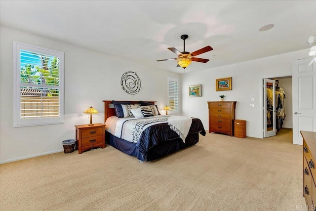 bedroom featuring carpet, a spacious closet, a ceiling fan, baseboards, and a closet