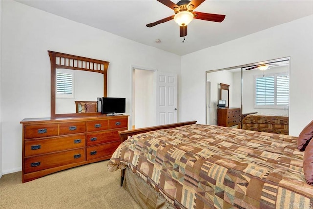 bedroom featuring multiple windows, light carpet, and a ceiling fan