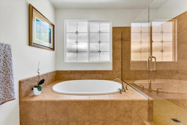 bathroom featuring a garden tub and a shower stall