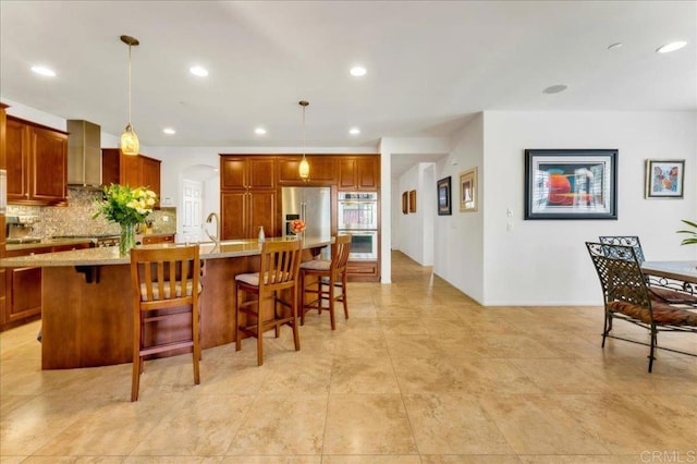 kitchen with stainless steel appliances, backsplash, a breakfast bar, a spacious island, and recessed lighting