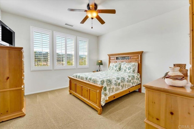 bedroom with light colored carpet, baseboards, and a ceiling fan