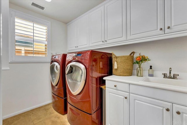 clothes washing area with cabinet space, washing machine and dryer, and baseboards