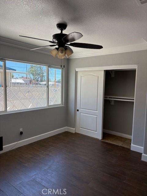642 S Rosario Ave, San Jacinto, CA 92583 - unfurnished bedroom featuring a textured ceiling, crown molding, dark wood finished floors, a closet, and ceiling fan