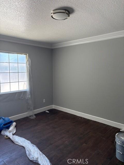 642 S Rosario Ave, San Jacinto, CA 92583 - unfurnished bedroom featuring ornamental molding, a textured ceiling, and dark wood-style floors