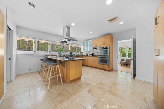 1212 Oakwood Dr, Arcadia, CA 91006 - kitchen with island range hood, stainless steel double oven, a breakfast bar area, baseboards, and recessed lighting