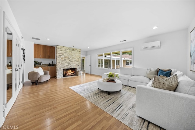 1212 Oakwood Dr, Arcadia, CA 91006 - living area featuring an AC wall unit, light wood-style flooring, a stone fireplace, and recessed lighting
