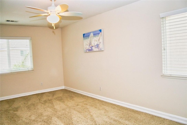 carpeted empty room featuring a ceiling fan and baseboards