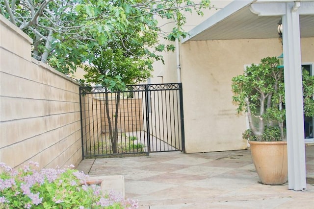 view of patio with fence and a gate