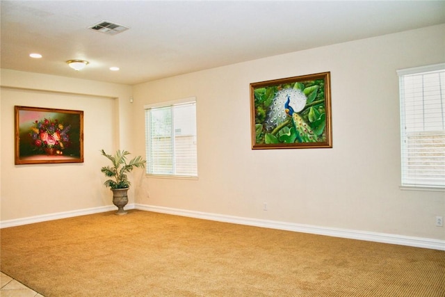 empty room featuring light carpet, baseboards, and recessed lighting