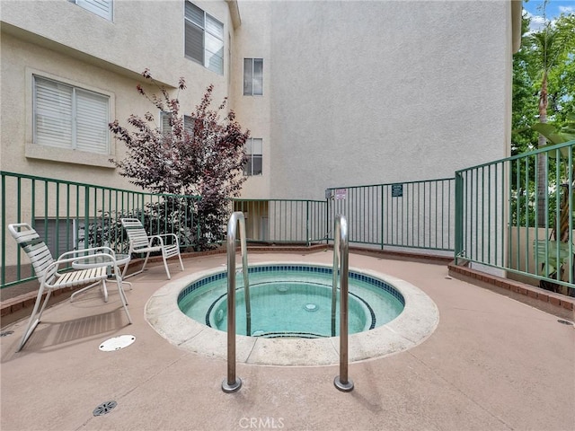 view of pool featuring a community hot tub and fence