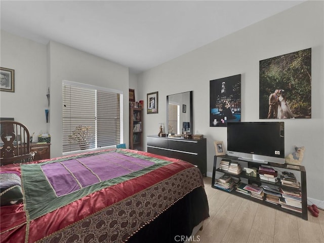 bedroom with light wood-style flooring and baseboards