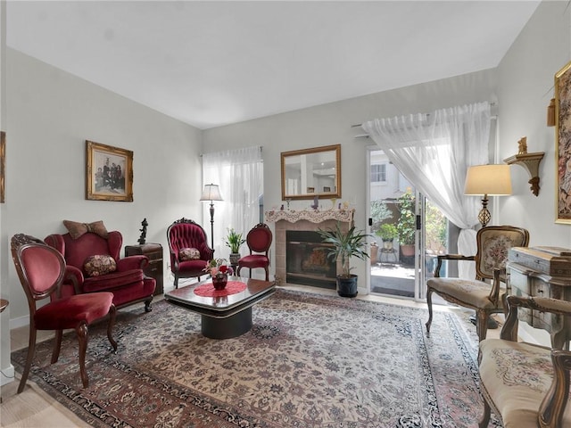 living room with healthy amount of natural light, a glass covered fireplace, wood finished floors, and baseboards