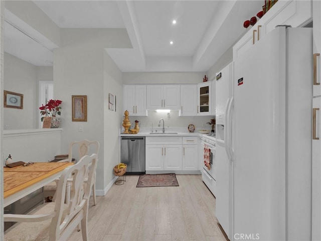kitchen featuring white appliances, a sink, white cabinetry, light wood-style flooring, and recessed lighting