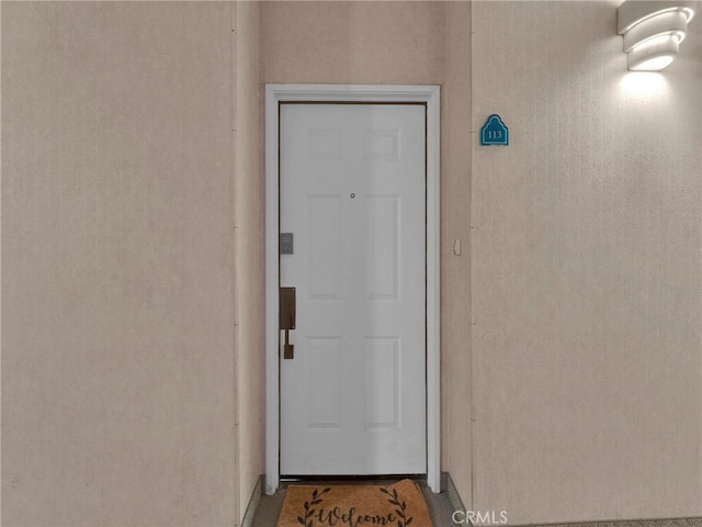 entrance to property featuring stucco siding