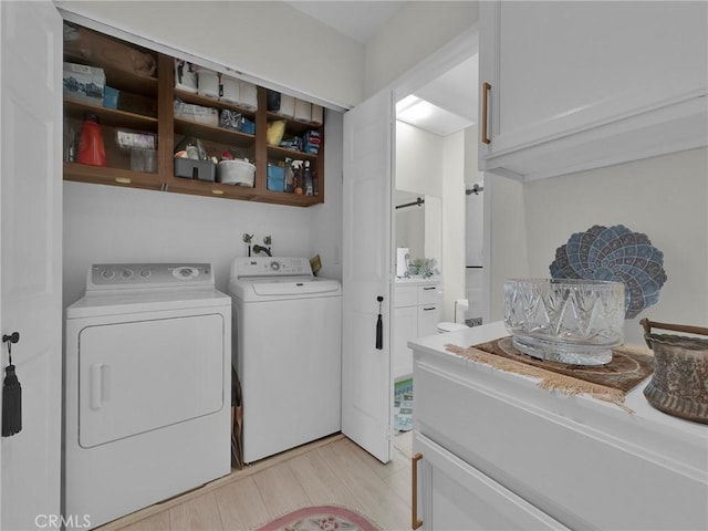 laundry area featuring independent washer and dryer and light wood finished floors