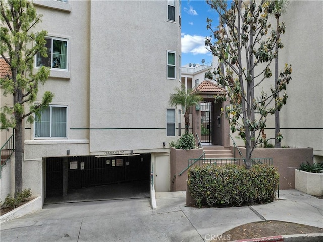 view of property featuring a garage, stairway, and concrete driveway