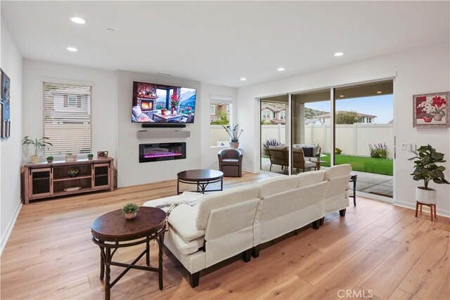 18100 Tableau Way, Saugus, CA 91350 - living room with a glass covered fireplace, light wood-style floors, plenty of natural light, and recessed lighting