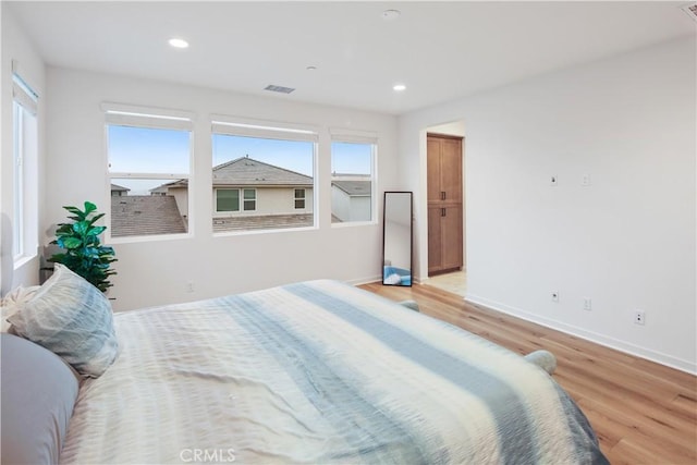 bedroom with light wood finished floors, baseboards, and recessed lighting