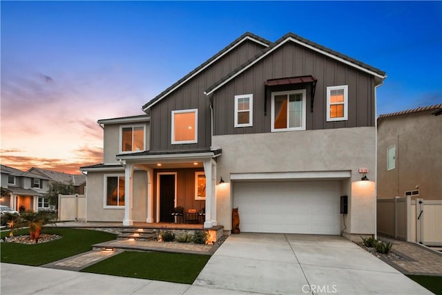 18100 Tableau Way, Saugus, CA 91350 - view of front facade with board and batten siding, concrete driveway, an attached garage, and covered porch