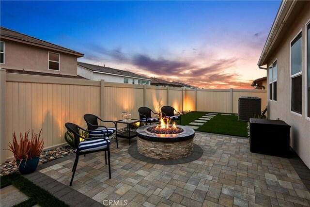18100 Tableau Way, Saugus, CA 91350 - patio terrace at dusk featuring a fire pit, central AC unit, a fenced backyard, and a patio