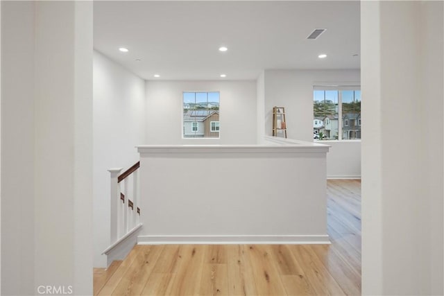 corridor featuring healthy amount of natural light, light wood-style flooring, and recessed lighting