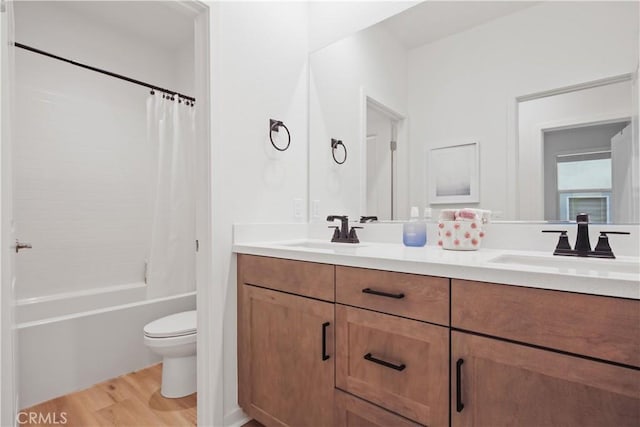 full bath featuring wood finished floors, double vanity, toilet, and shower / bathtub combination with curtain