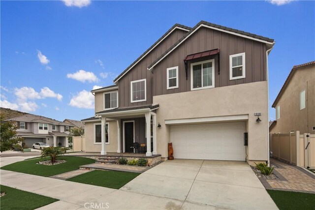 18100 Tableau Way, Saugus, CA 91350 - traditional-style home with board and batten siding, an attached garage, concrete driveway, stucco siding, and a porch