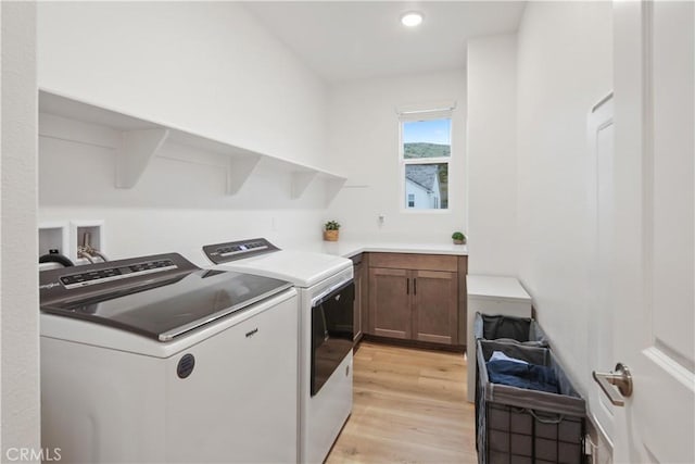 laundry room featuring washer and clothes dryer, light wood-type flooring, cabinet space, and recessed lighting