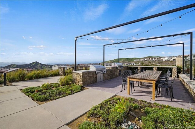 18100 Tableau Way, Saugus, CA 91350 - view of home's community with exterior kitchen, a mountain view, and outdoor dining space